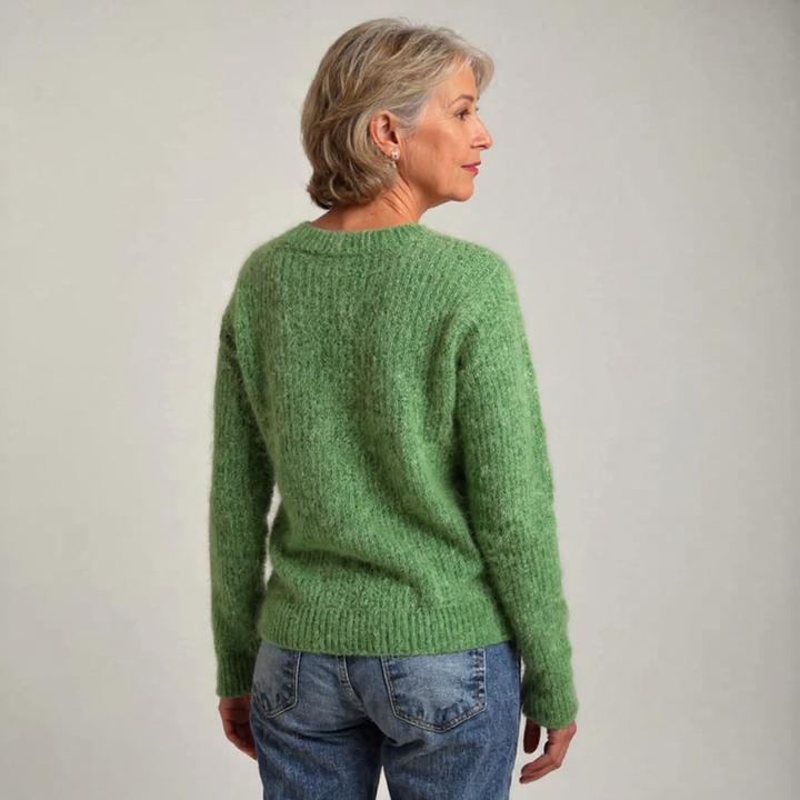 Elfriede Pullover mit Schafen in Grün – ein weiches Wiesengrün mit einer Reihe kleiner weißer und schwarzer Schafe über der Brust – Stefan Berlin