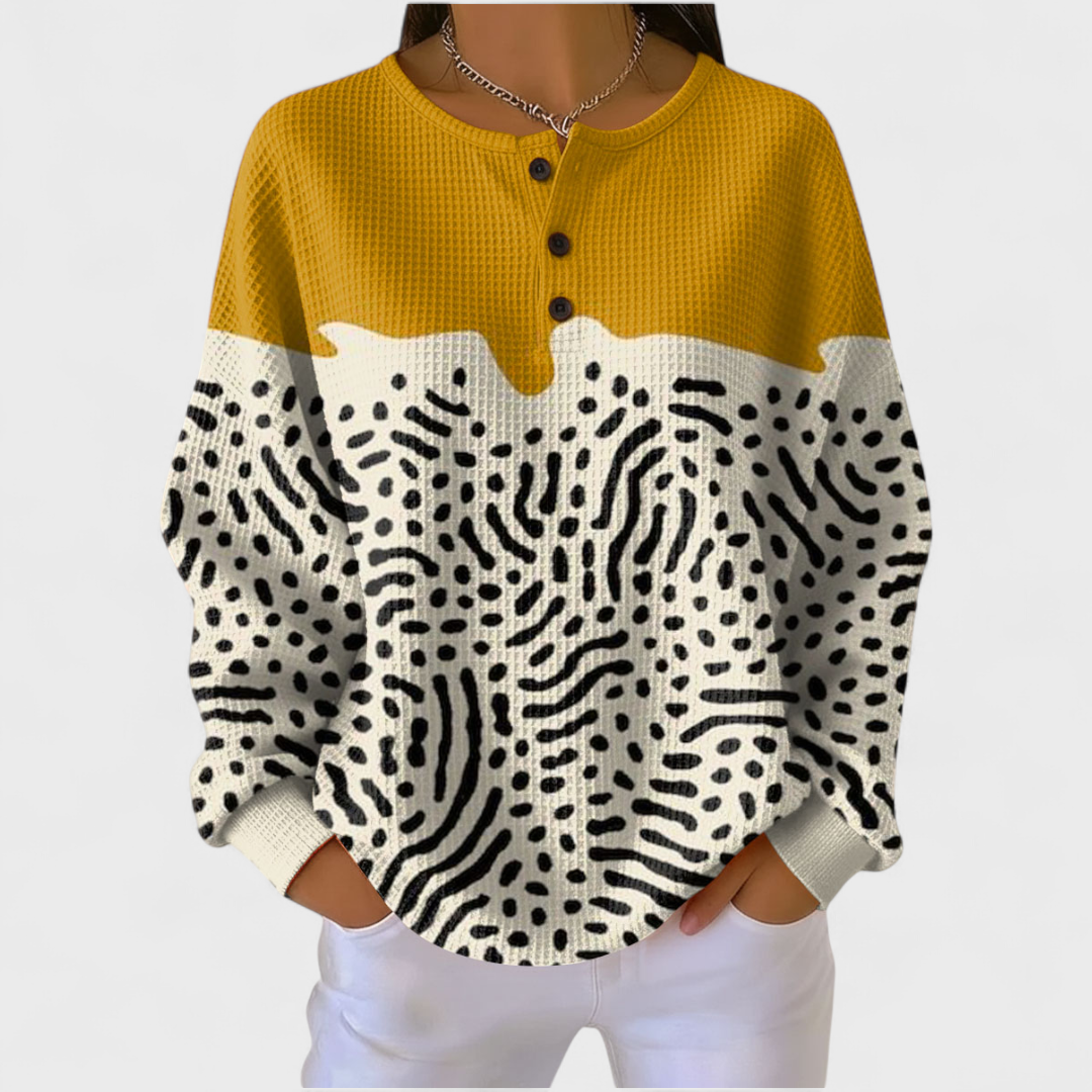 Dietlinde Pullover mit Formen in Ocker – ockergelbe Fläche oben, darunter Creme mit schwarzen Punkten und geschwungenen Linien – Stefan Berlin